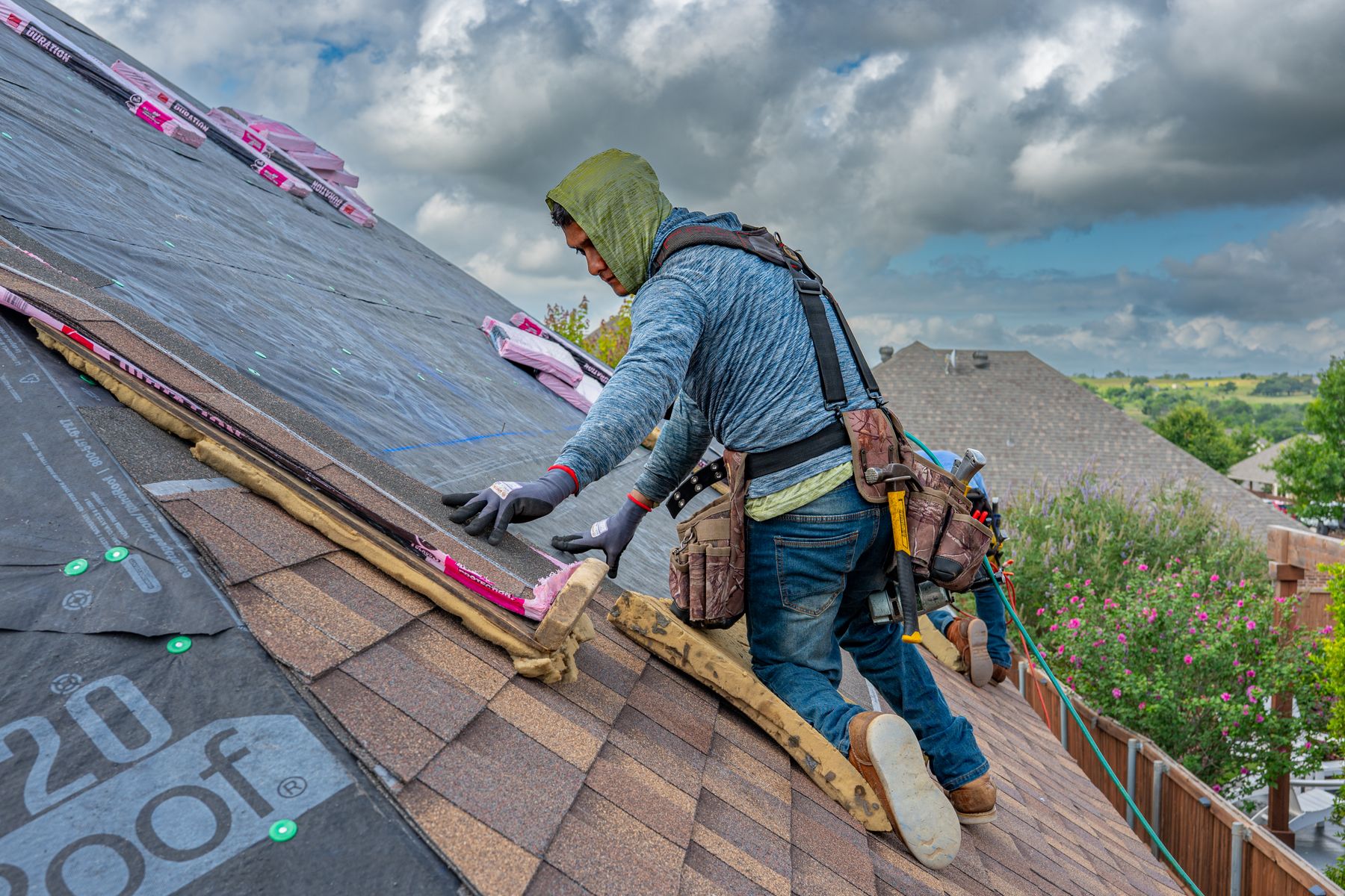 Roofer installing asphalt shingles on a residential roof